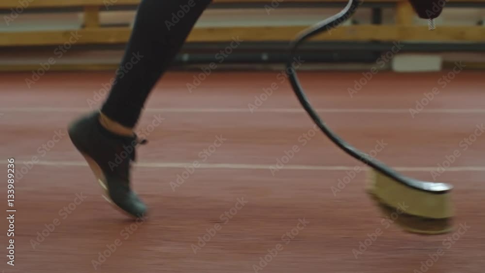 Low section of leg and prosthetic limb of amputee athlete running on track Low section of leg and prosthetic limb of amputee athlete running on track