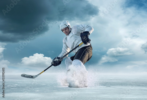 Canvas Print Ice hockey player in action outdoor around mountains