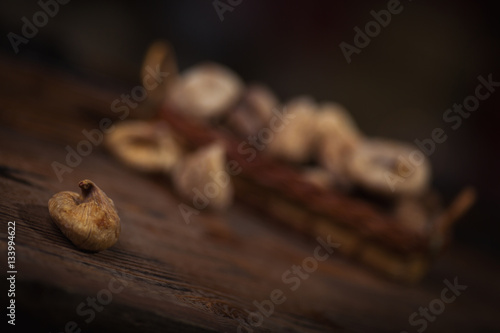 Dried figs in a small basket on wooden background