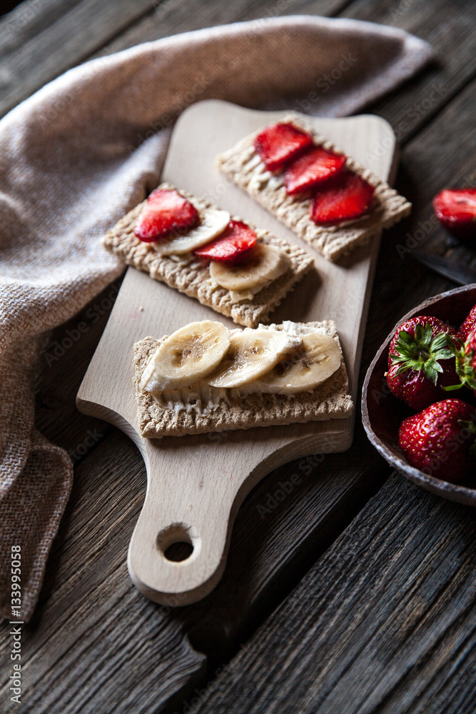 Fruity toast on wooden background. Strawberries, bread, butter and cheese.Vintage style Fruity toast on wooden background. Strawberries, bread, butter and cheese.Vintage style