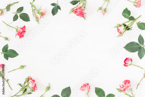 Flowers composition. Frame with rose flowers on wooden white background. Flat lay, top view