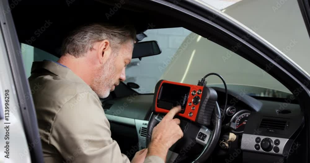 Mechanic using a diagnostic tool Mechanic using a diagnostic tool