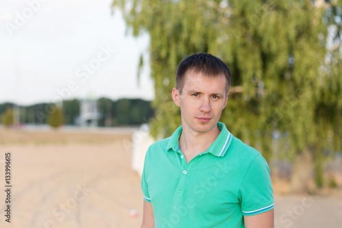 Portrait of beautiful young man on the beach at summer