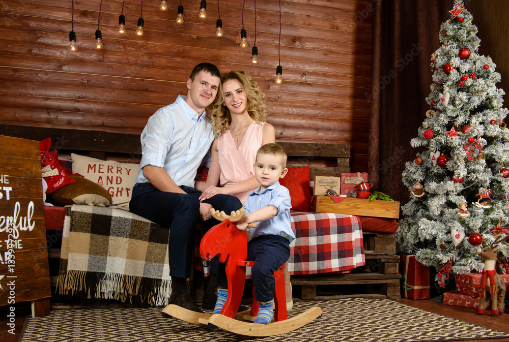 boy on a rocking horse with a happy family at Christmas