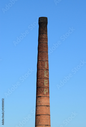 brick factory chimney. Tube for propulsion bricks in the furnace. Pipe on a background of blue sky