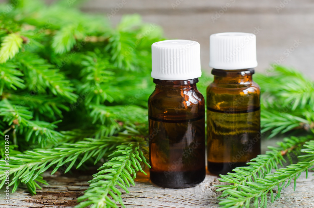 Two bottles of essential oil and fir branches. Aromatherapy and spa products Two bottles of essential oil and fir branches. Aromatherapy and spa products