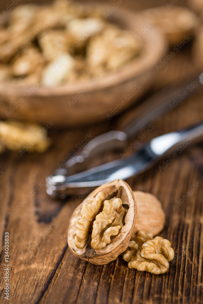 Portion of Cracked Walnuts on wooden background (selective focus Portion of Cracked Walnuts on wooden background (selective focus