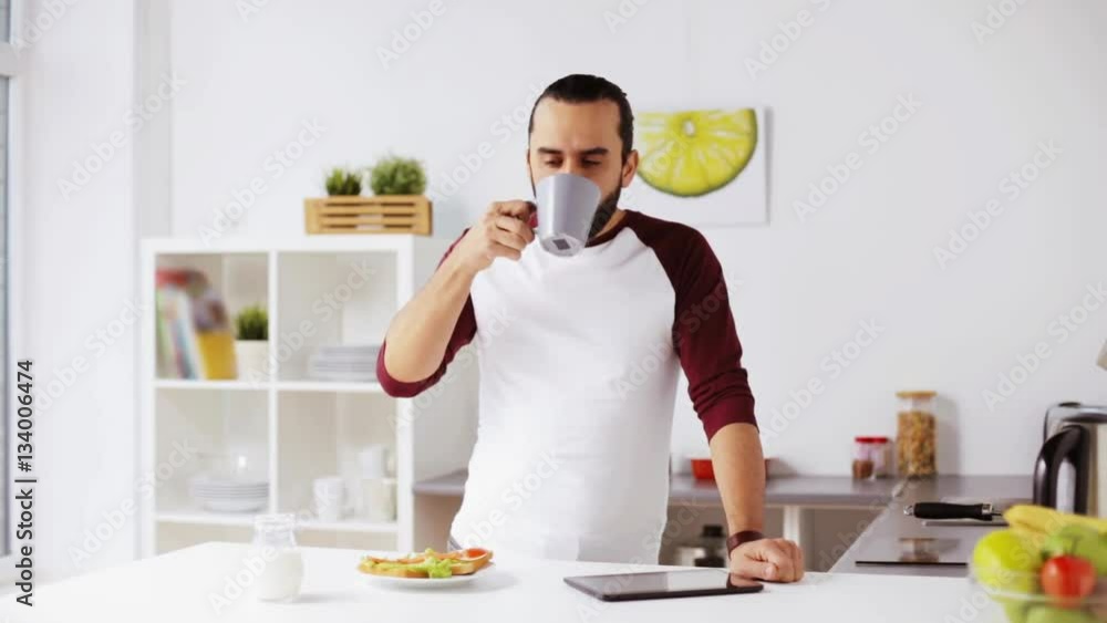 man with tablet pc eating breakfast at home man with tablet pc eating breakfast at home