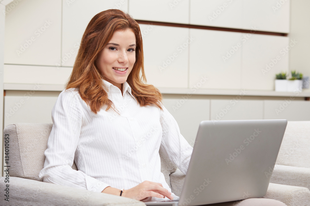 Young girl thinks about purchasing through the internet sitting on the sofa Young girl thinks about purchasing through the internet sitting on the sofa
