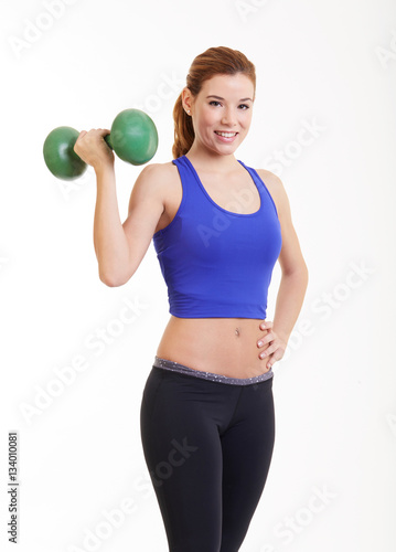 Muscular young woman exercising in sports outfit with dumbbells on white background