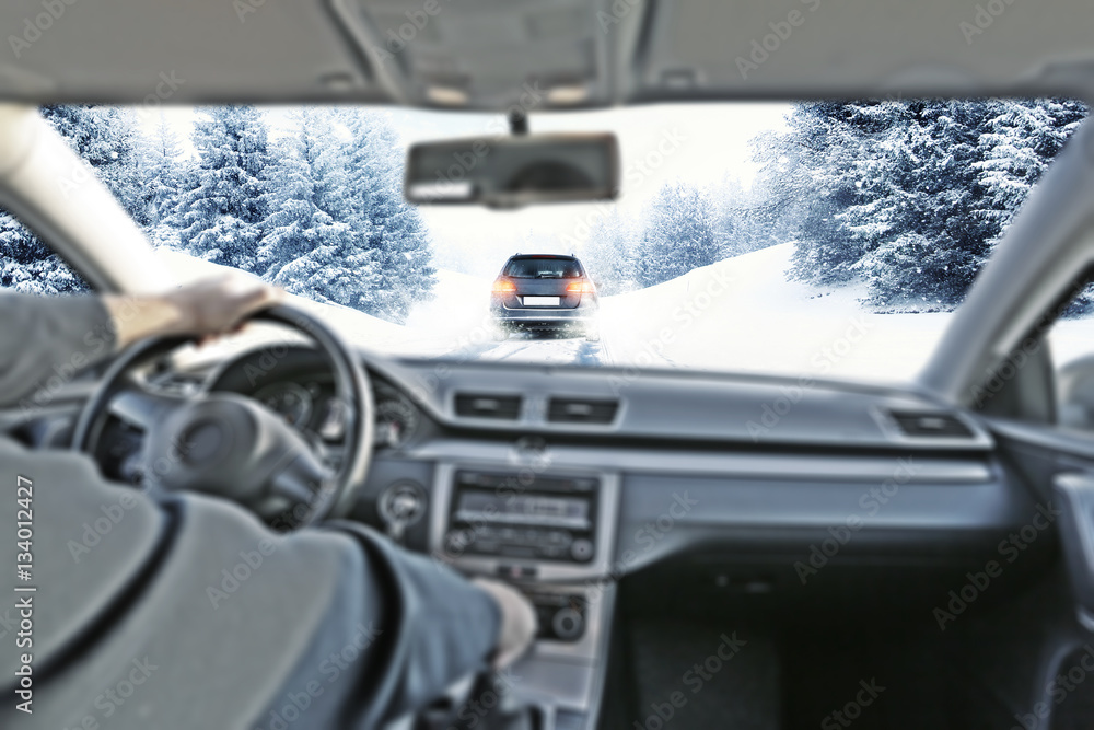 car interior with driver and winter road 