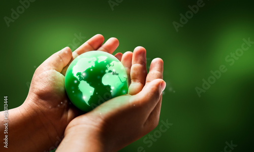 Save world save life concept.The globe in hands with green color background