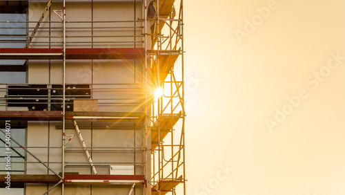 Baugerüst auf einer Baustelle Gewerbebau mit Sonnenstrahlen im Gegenlicht