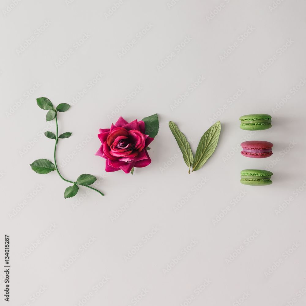 Φωτογραφία Word LOVE made out of flower, leaves and macarons. Flat lay. Lov
