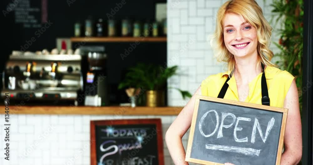 Portrait of waitress standing with open sign board Portrait of waitress standing with open sign board
