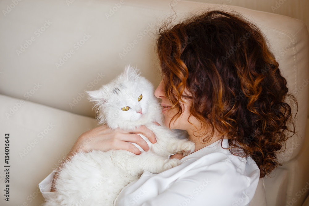 Cute girl with curly hair hugging white fluffy cat Cute girl with curly hair hugging white fluffy cat