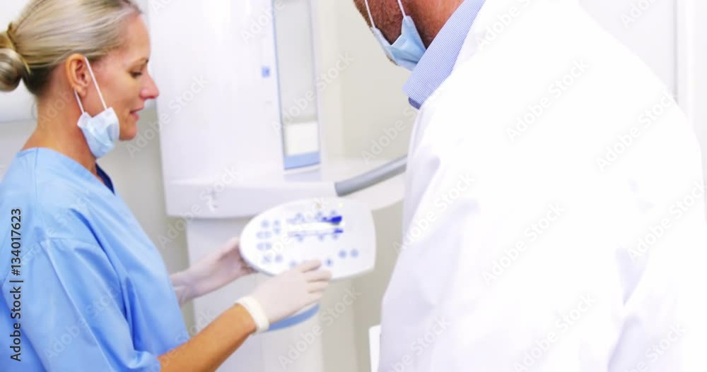 Smiling dentist talking to dental assistant Smiling dentist talking to dental assistant