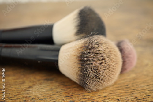 Macro detail of set of cosmetic brushes used as applicators of make-up on wooden background as a symbol of women's cosmetics and fashion 