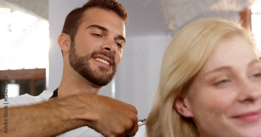 Woman getting his hair trimmed with scissor Woman getting his hair trimmed with scissor