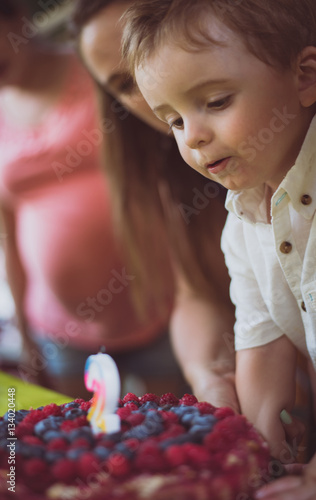 Little boy blowing birthday candle