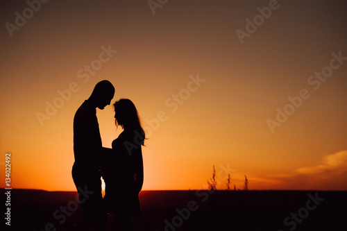 couple in love against the backdrop of a beautiful sunset. Pregnancy