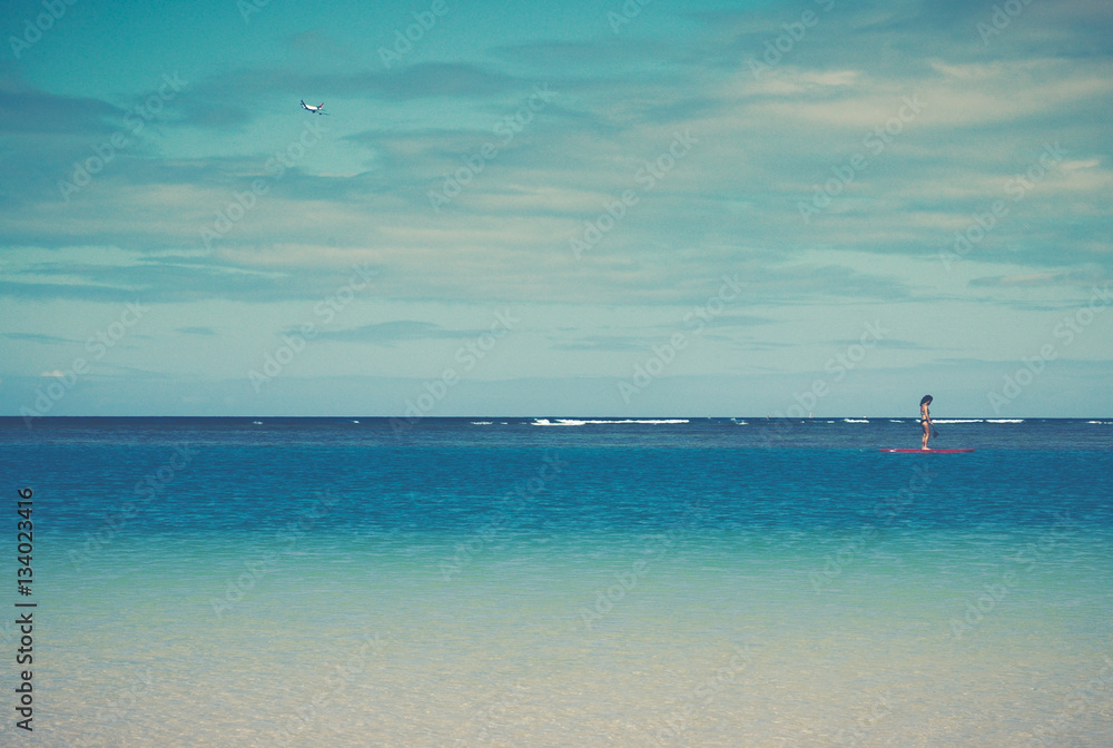 Retro Filtered Tropical Ocean Scene With Paddleboard and Plane