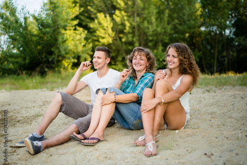 Mature mother with children having chocolate bar