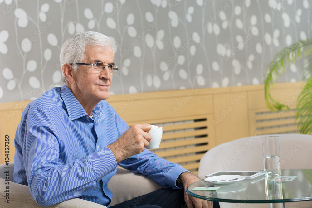 Senior Businessman drinking coffee in a hotel lobby Senior Businessman drinking coffee in a hotel lobby
