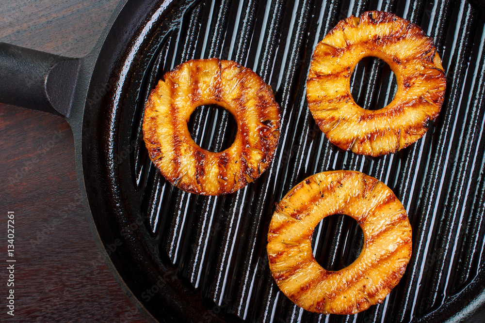 Fresh cooked pineapple slices on cast iron grill pan