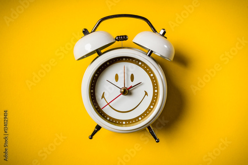 small white clock placed on a yellow background