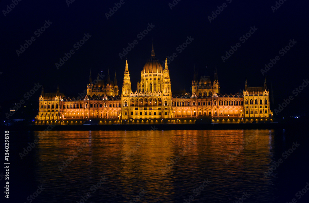 View on the illuminated Parliament of Budapest across the river Danube on a winter night