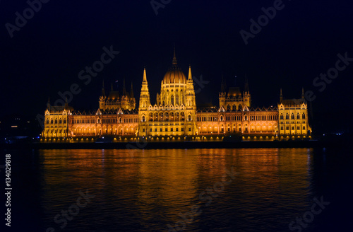 View on the illuminated Parliament of Budapest across the river Danube on a winter night