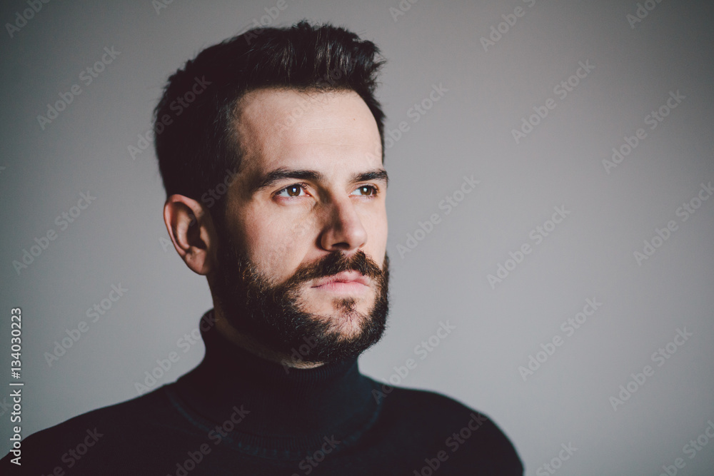 Portrait of a handsome bearded young man looking a side Portrait of a handsome bearded young man looking a side