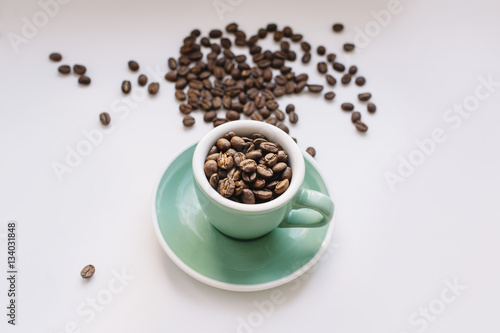 fresh morning coffee beans in a small espresso cup on a white background