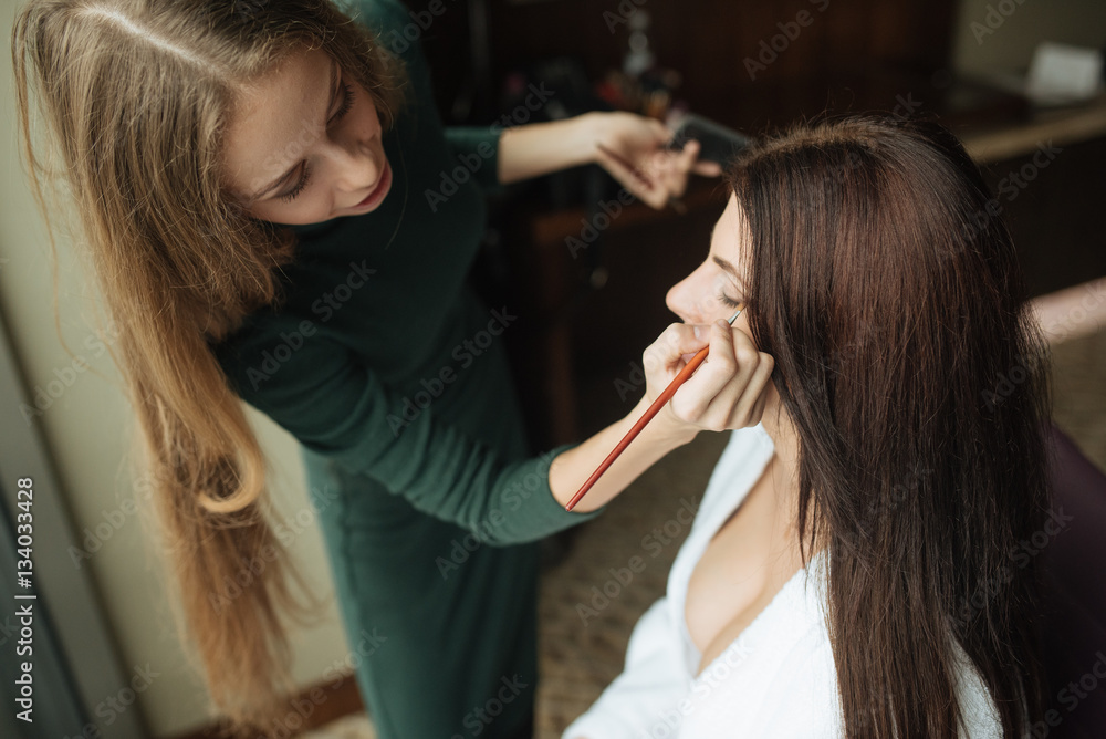 Fototapeta premium Wedding makeup artist making a make up for bride.