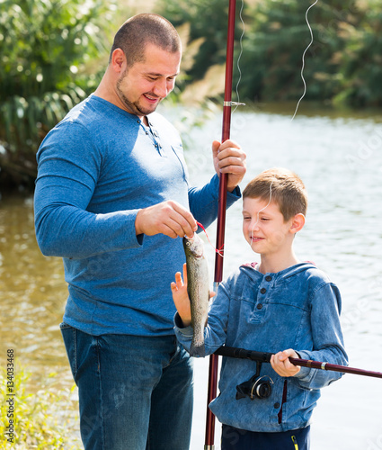 Friendly father and son fishing with rods