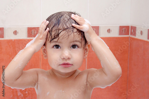cute baby is swimming in bath