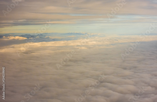 Aerial view of clouds and mountains at sunset