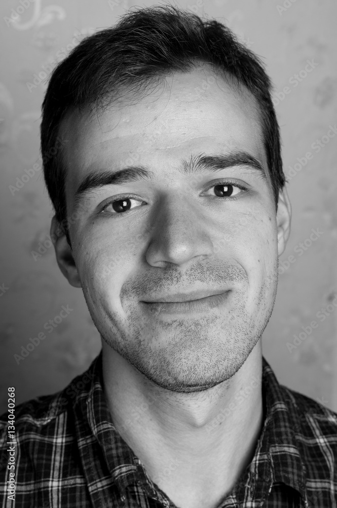 black and white portrait of handsome smiling man isolated on gray studio background posing to the camera black and white portrait of handsome smiling man isolated on gray studio background posing to the camera