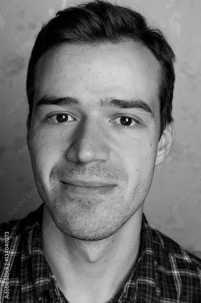 black and white portrait of handsome smiling man isolated on gray studio background posing to the camera black and white portrait of handsome smiling man isolated on gray studio background posing to the camera