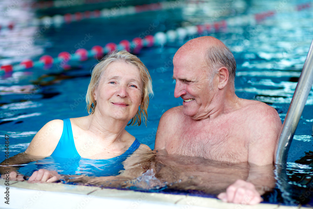 Fototapeta premium Happy healthy active senior couple having fun together in the swimming pool