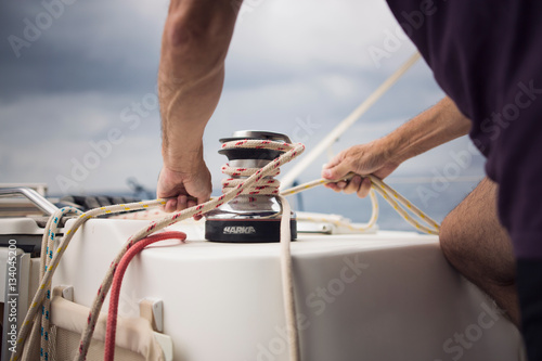 Man using a winches on his sailboat