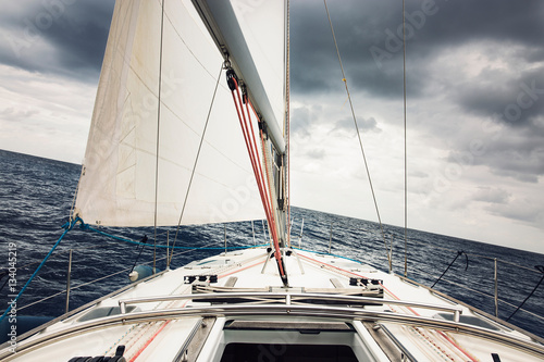 Sailboat sailing through the Mediterranean under a storm.