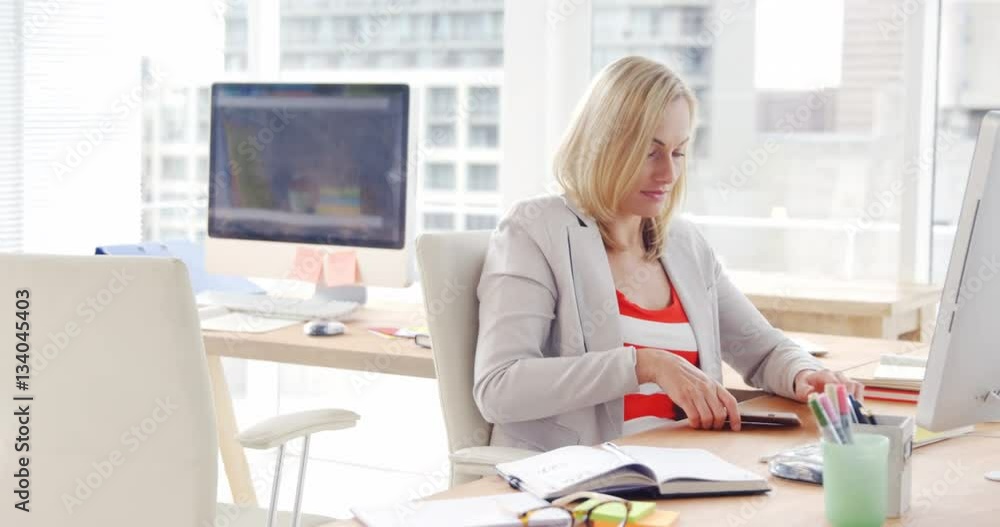 Businesswoman talking on the mobile phone at her desk Businesswoman talking on the mobile phone at her desk