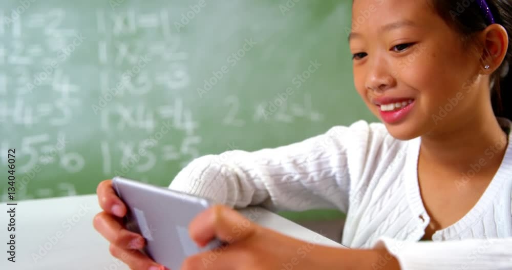 Schoolgirl using mobile phone in classroom at school Schoolgirl using mobile phone in classroom at school