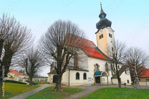 The parish Church of St. Gallus in the municipality Schoerfling am Attersee during snowfall. Upper Austria.  photo