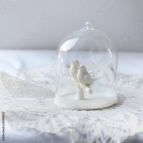 figures of two doves in glass dome on light abstract background. symbol of love, romance. Valentine's day greetings concept, wedding day.