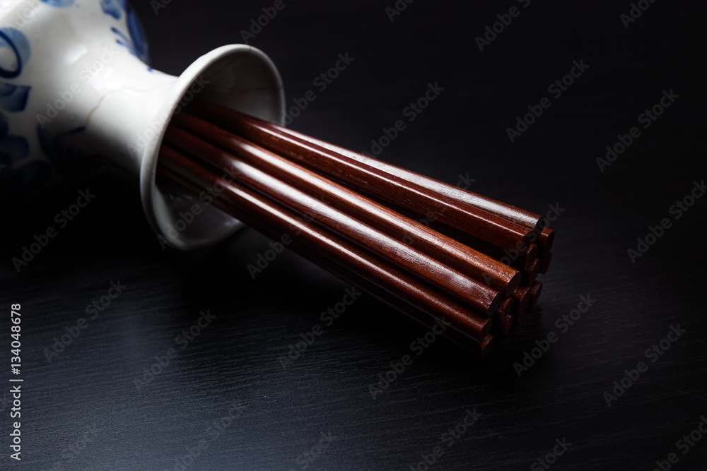 Naklejka premium Brown chinese wood chopsticks in traditional russian slyle vase