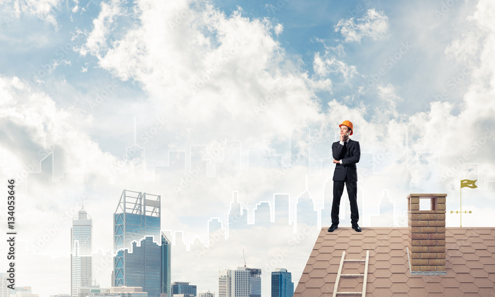 Engineer man standing on roof and looking away. Mixed media Engineer man standing on roof and looking away. Mixed media