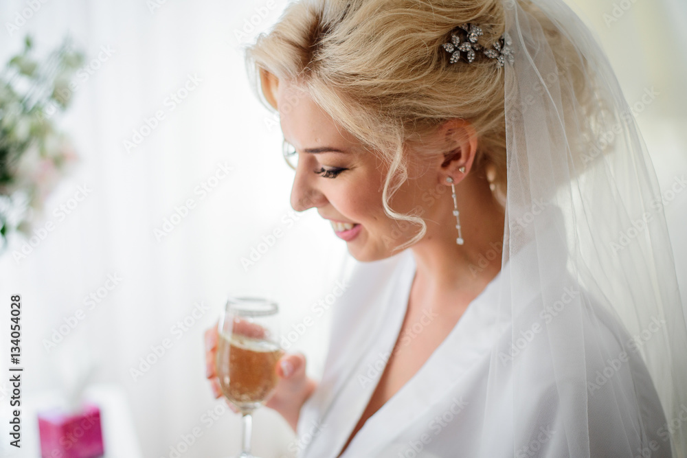 Picture of charming blonde bride in silk robe holding champagne Picture of charming blonde bride in silk robe holding champagne